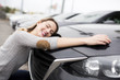 © Louis-Paul Photo - Jolly young female driver hugging her new car