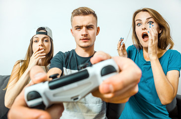 Wall Mural - Gripped teens friends having fun playing a video game competition, stress emotion