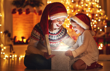 Wall Mural - merry christmas! family mother and child with magic gift at home