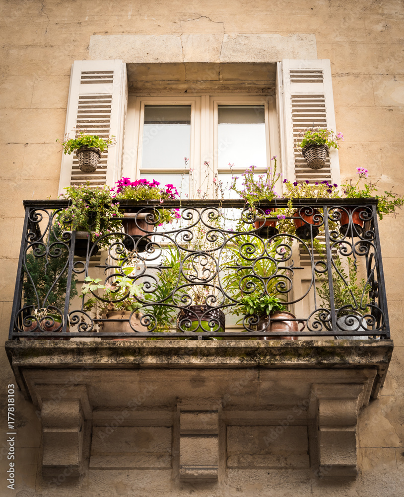 Photo Stock Mediterranean balcony full of colored flowers and plants, a  double door with shutters gives access to this little paradise with a  classic look. | Adobe Stock