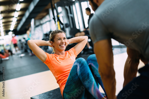 Cuadros en Lienzo Young beautiful woman doing exercises with personal trainer