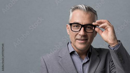 Cuadros en Lienzo Smart businessman with glasses posing