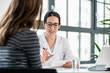© Kzenon - Female physician listening to her patient during consultation while sitting down in the office of a modern medical center