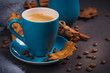 Blue cup of coffee with coffee beans and autumnal dry leaves