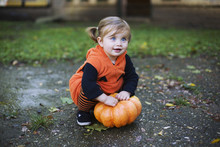 Cute Little Girl Dressed Up In A Pumpkin Halloween Costume