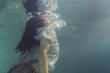 © Jovana Milanko/Stocksy - Dressed up woman diving out from the pool underwater