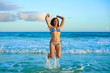 © lunamarina - Latin bikini girl jumping in Caribbean beach