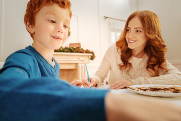 Wall Mural - Proud mother smiling while looking at preteen son