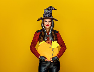 Sticker - smiling modern woman isolated on yellow showing pumpkin