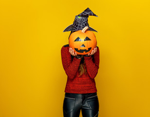 Wall Mural - woman holding sad jack-o-lantern pumpkin in front of face