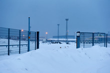 Light Posts And Fence And Gate In Snow On A Lightless Winter Evening In Helsink, Finland