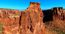 Steep Red Butte Against Blue Sky In Desert Landscape - Colorado National Monument, USA