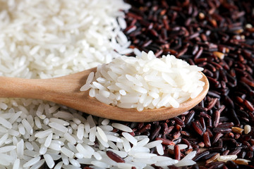 Wall Mural - Jasmine rice in wooden spoon on pile rice background.