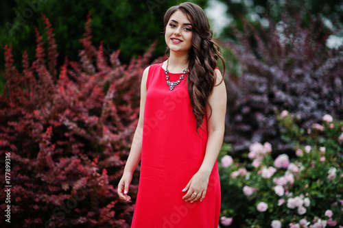 Zdjęcie XXL Portret attractve młoda dziewczyna w czerwieni smokingowy pozować na bruku w parku na balu dniu.