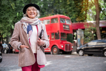 Wall Mural - Excited senior lady standing on street