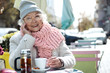 © Yakobchuk Olena - Joyful old woman drinking tea in cafeteria outdoor