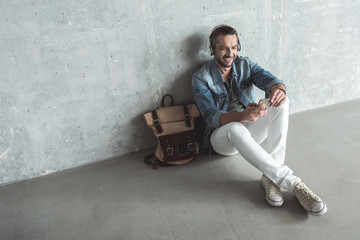 Wall Mural - Fashionable adult guy is enjoying his playlist