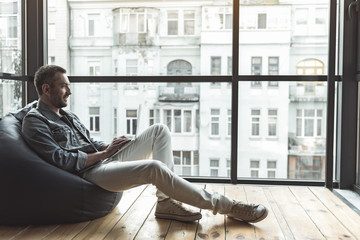 Wall Mural - Happy bearded guy is using modern device