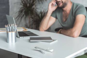 Wall Mural - Cheerful young employee is talking on smartphone