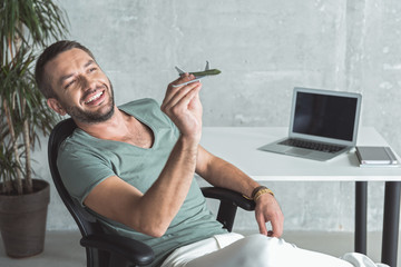 Wall Mural - Joyful man is holding plane