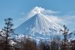 Winter volcanic landscape of Kamchatka Peninsula: view of eruption active Klyuchevskoy Volcano in sunny day clear weather. Eurasia, Russian Far East, Kamchatka Region, Klyuchevskaya Group of Volcanoes