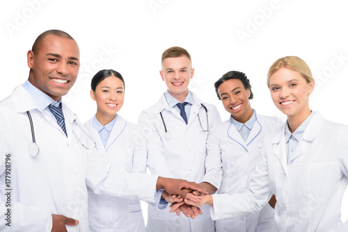 Plakat wieloetniczni lekarze z rękami razem