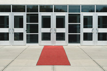 A Red Carpet Leads To The Door Of A Metal And Glass Building