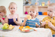 © Andrey Kuzmin - funny children group eating fruits in kindergarten dinning room