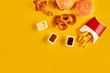 © nazarovsergey - Fast food dish top view. French fries, hamburger, mayonnaise and ketchup sauces on yellow background.