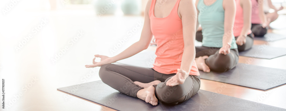 Attractive young Asian woman group exercising and sitting in yoga lotus position in yoga classes - obrazy, fototapety, plakaty 
