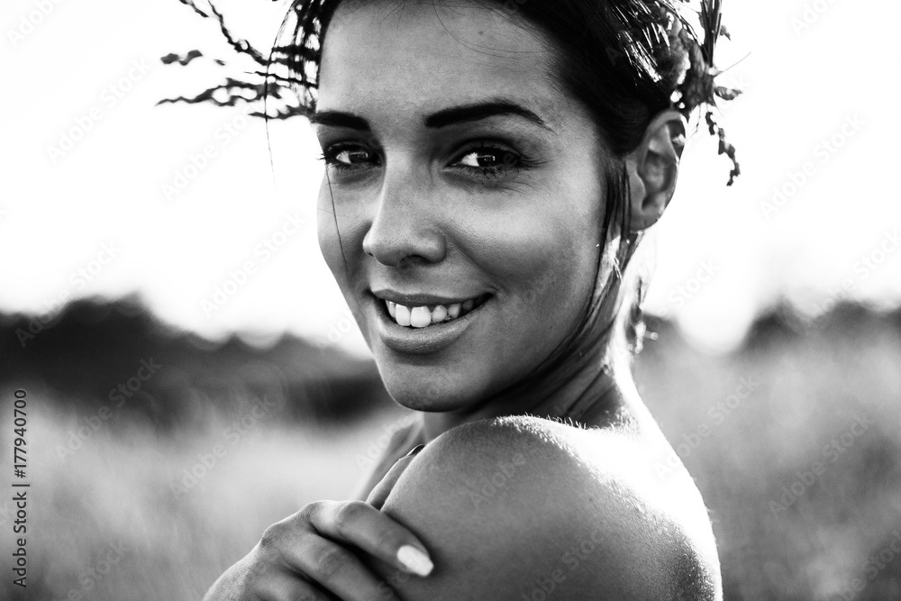 Black and white portrait of a beautiful young woman in sunny fields ...
