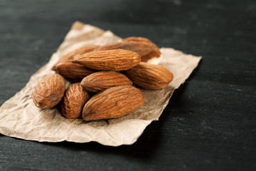 Almond on a piece of wrinkled craft paper on a wooden table