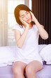 © geargodz - woman with headache on bed in bedroom