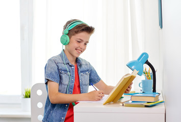 Wall Mural - student boy in headphones writing to notebook