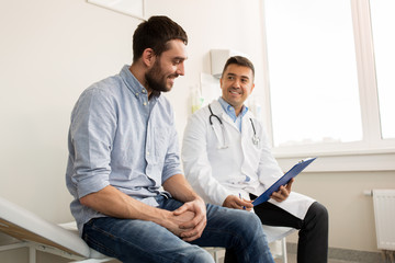 smiling doctor and young man meeting at hospital