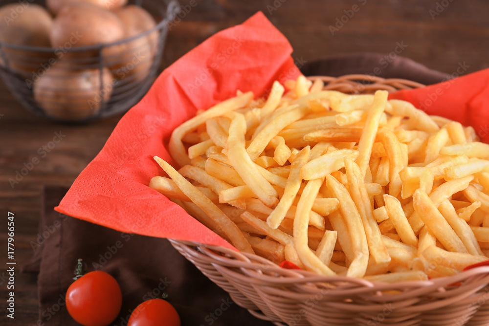 Basket with yummy french fries on table