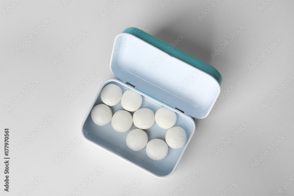 Open box with hard mint candies on light background