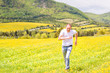 © Andriy Blokhin - Young man running, jumping in air and smiling on countryside yellow dandelion flower fields in summer grass in Ile D'Orleans, Quebec, Canada happy