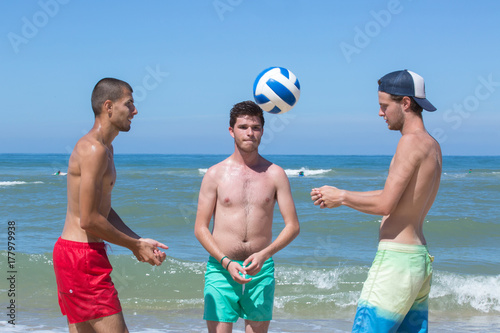 Plakat fitness mężczyzn grać w siatkówkę na plaży