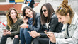 © guruXOX - Four girl friends happy watching internet social media in smartphone