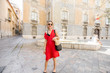 © rh2010 - Young woman tourist in red dress walking the street in the old town of Valencia city, Spain