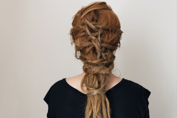 Ginger woman with dreadlocks. Interesting hairstyle. Braid with knots