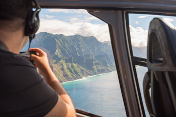 napali coast from a helicopter with a tourist taking pictures