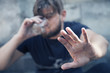 © zwiebackesser - man holding a glass of vodka and stretches hand as if he wants to say: I do not need your help. Drunk young people. (alcoholism, pain, pity, hopelessness, social problem of dependence concept)