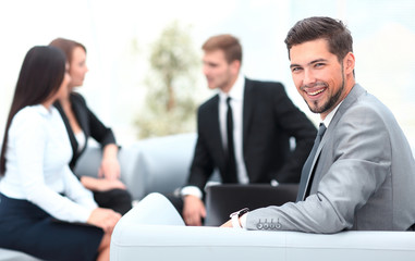 Poster - businessman sitting in an office on the background of business team.