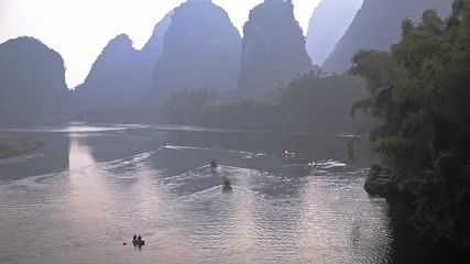 Sticker - Handheld shot of sunrise over landscape of Yangshuo, China. Boats floating in Li River in karst mountains top view. Travel, adventure and picturesque famous destination concept.