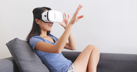 Wall Mural - Woman watching with virtual reality device at home