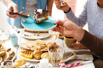 Wall Mural - Man putting piece of chocolate cake on saucer of one of guests at party