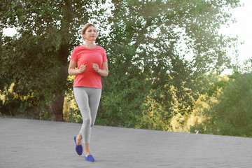 Wall Mural - Beautiful mature woman running outdoors