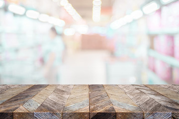 Poster - Empty tropical wood table and blurred people shopping at supermarket light background. product display template.Business presentation.